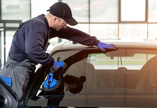 technician replacing car windshield
